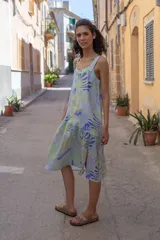 Vestido midi con estampado floral en tonos rosa y rojo, de breteles finos y corte evasé con abertura lateral.