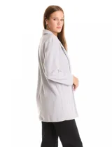 Blazer de tejido soft color beige, con silueta relajada y corte largo. Presenta cuello con solapas muesca, frente abierto sin botones y dos bolsillos de parche frontales.