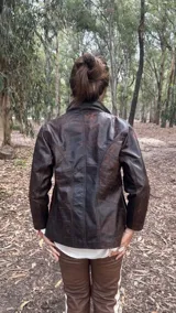 Campera de cuero con efecto envejecido en tonos marrones, de calce relajado y estructurado, con cuello alto y cierre frontal.