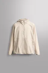 Chaqueta cortavientos de Zara Athleticz color beige, de tejido técnico ligero y elástico, con cuello subido, capucha, cierre frontal de cremallera y bolsillos laterales con cierre oculto.