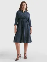 Vestido camisero midi azul marino con rayas verticales blancas, cuello camisero, cierre frontal con botones, mangas largas con puños abotonados y cinturón de lazo a juego.