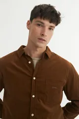 Camisa marrón de pana fina, corte regular fit, con cuello solapa clásico, bolsillo en el pecho y botones personalizados.