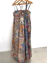 Vestido largo de algodón con estampado multicolor, corte cuadrado y elástico en la espalda. Incluye un aplique de flor desmontable.