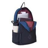 Mochila Maui and Sons modelo Explorer, color azul con base y bolsillo frontal negros. Tiene un parche circular con el logo de la marca en la parte superior y un parche de goma con un diseño geométrico en el bolsillo frontal. Cuenta con un compartimento principal, un bolsillo frontal con cierre y bolsillos laterales de malla.
