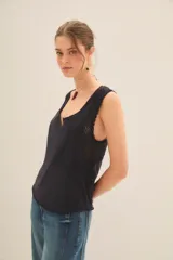 Musculosa negra con escote en V y detalles de encaje en los laterales.