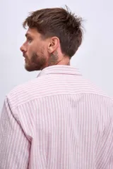 Camisa de manga larga color rosa claro con botones. Corte clásico.