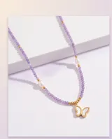 Collar de acero con baño de oro, piedras naturales violetas, perlas cultivadas y un dije colgante en forma de mariposa con nácar.