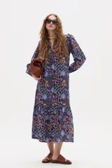 Vestido midi de lino con estampado floral, cuello mao, mangas largas con puños elásticos y corte holgado con frunce en el ruedo.