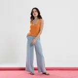 Top tejido color naranja, sin mangas, con escote redondo y detalle de punto calado en el ruedo inferior con borde festoneado.