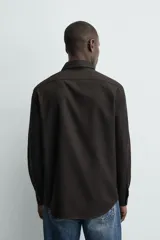 Camisa de corte regular fit en color bordó, con cuello italiano, manga larga con puños abotonados y cierre frontal de botones.