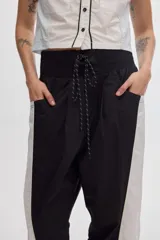 Pantalón colorblock confeccionado en algodón, con diseño bicolor en negro y blanco, cintura elástica ajustable con cordón y bolsillos laterales.