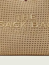 Cartera Marc Jacobs modelo The Lurex Crochet Sack Bag, color beige y dorado, tipo tote bag tejida en crochet de lurex con el texto 'THE SACK BAG MARC JACOBS' bordado en el frente.