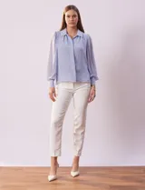 Camisa blanca de gasa marca Tahari, con cuello con solapa y abertura central con botones ocultos. Manga larga con puño y botones.