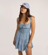 Vestido corto de silueta evasé color celeste, con escote recto y detalle de lazo en el centro. Posee breteles medianos, cintura elástica fruncida y falda con volados escalonados.