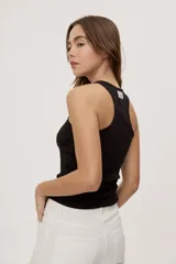 Musculosa de algodón con elastano, de textura acanalada y calce al cuerpo, color marrón topo con cuello redondo y sisas amplias.