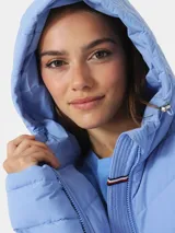 Campera puffer celeste con capucha y cierre frontal con cremallera.