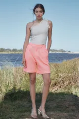 Bermuda de tiro alto color salmón con textura broderie, corte amplio, pinzas delanteras y ruedo con dobladillo.
