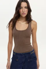 Musculosa de tejido rib color crudo, con lurex incorporado y escote redondo, de calce ajustado al cuerpo.