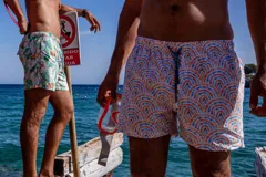 Short de baño Von Braun con estampado de arcos en tonos naranja y azul sobre fondo blanco. Cuenta con cintura elástica, dos bolsillos laterales, un bolsillo trasero con etiqueta de la marca y red interior.