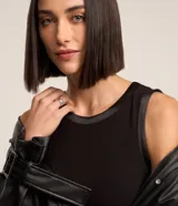 Musculosa básica de cuello redondo, confeccionada en tejido de viscosa con elastano. Presenta un diseño sin mangas con terminaciones en satén en las sisas.