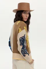 Cardigan de punto con ilustraciones en jacquard y detalle bordado en el frente, mangas largas con puños acanalados, escote redondo y cierre frontal de botones.