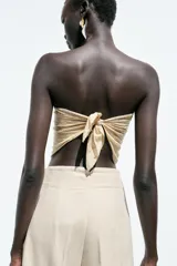 Pantalón de lino negro, de tiro alto, con bolsillos delanteros de vivo, pernera recta y cierre frontal con cremallera, botón interior y gancho metálico.