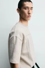 Sudadera de corte relajado confeccionada en tejido de algodón, con cuello redondo y manga corta. Presenta una aplicación de parche combinado a tono en la parte frontal y trasera.