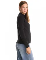 Buzo de tejido de punto color beige, con cuello alto y mangas largas. Presenta un diseño de calce ajustado con puños y ruedo acanalados.