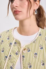 Cazadora capitoneada de corte recto, con diseño de rayas verticales verdes y estampado floral. Presenta cuello redondo, cierre frontal con botones y bolsillos laterales de parche.
