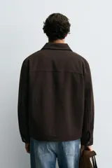 Cazadora de corte relajado confeccionada en una mezcla de lyocell y algodón con interior acolchado. Presenta cuello solapa, cierre frontal con botones, mangas largas con puños abotonados y dos bolsillos de plastrón en el pecho.