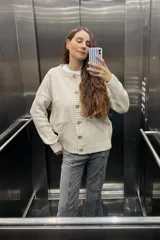 Saco tejido de lana color arena con cuello redondo, cierre con botones marrones y bolsillos frontales. Diseñado y hecho en Uruguay.