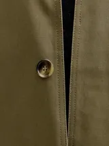 Campera larga de corte clásico, color verde oliva, con cuello de pana en contraste color marrón y cierre frontal de botones. Presenta un diseño funcional con bolsillos laterales integrados y estructura resistente.