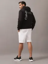 Buzo con capucha Calvin Klein de color negro, con diseño liso, mangas largas y puños y dobladillo de punto canalé. Presenta el logotipo de la marca estampado en el pecho.