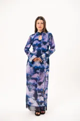 Vestido largo de manga larga con terminación campana, de color azul y violeta con estampado tie-dye, cuello mao con ojal y tajo frontal. Cuenta con flecos en el ruedo y tajo en la pierna.
