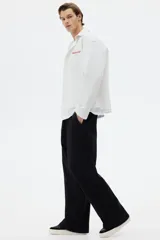 Pantalón de jogging de felpa de algodón pesado, con corte de pierna ancha y silueta relajada. Presenta cintura elástica con cordón ajustable, bolsillos laterales al bies y un bolsillo de parche en la parte trasera.