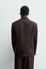 Blazer de traje cruzada de corte regular fit, color marrón oscuro, con solapas de muesca, bolsillos de doble vivo en la cadera y cierre frontal de botonadura doble.