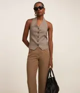 Pantalón zanahoria de sastrería color blanco, con cintura alta, trabillas y botón contrastante.