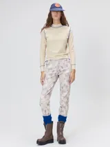 Polera de cuello alto confeccionada en tela rib color blanco, con mangas largas y hombreras. Presenta pespuntes en contraste en las terminaciones del cuello, hombros y puños.