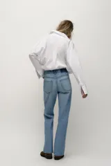 Jeans de tiro alto con diseño de cinco bolsillos, pernera recta y corte largo. Presenta cierre frontal con cremallera y botón metálico.