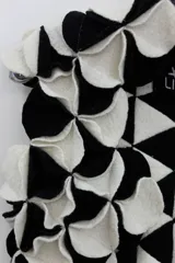 Chaleco negro con apliques circulares de lana merino afieltrada, teñida artesanalmente.