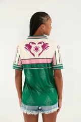 Camiseta deportiva estilo polo de manga corta, con diseño multicolor en tonos verde, blanco y rosado, cuello tipo polo y estampado gráfico frontal de la marca Farm.