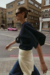 Jersey de punto con cuello redondo y mangas anchas tipo murciélago. Presenta un diseño de corte holgado con terminaciones en rib a tono en el cuello, puños y bajo.