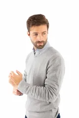 Sweater de punto con escote en V y mangas largas, confeccionado en una mezcla de algodón, nylon y spandex. Presenta un diseño clásico de corte recto con puños y ruedo acanalados.