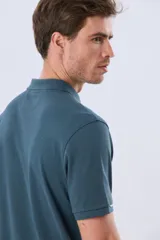 Remera polo de piqué de algodón color azul, de manga corta, con cuello camisero, cierre frontal de dos botones y pequeño logo bordado en el pecho.