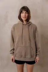 Buzo canguro oversize color marrón con efecto washed y acabado desgastado. Cuenta con capucha con cordones ajustables al tono, bolsillo frontal tipo canguro y terminaciones de rib en puños y cintura.