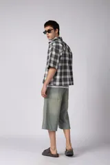 Camisa de manga corta de popelina cuadrillé en tonos marrón, blanco y gris, con diseño boxy fit, cuello camisero, cierre frontal de botones, bolsillo en el pecho con detalle bordado y dobladillo recto.