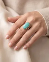 Anillo de plata 925 con una gran piedra natural turquesa de forma ovalada en el centro.