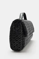 Bolso tipo sobre con diseño trenzado, asa de mano superior y cierre de solapa con imán.