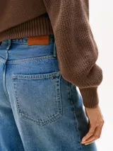 Pantalón corto de jean celeste, de corte recto y tiro medio. Con diseño de cinco bolsillos, cierre de cremallera y botón, y parche de logo Tommy Hilfiger en la parte posterior de la cintura.