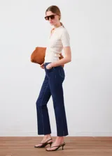 Jeans de corte flare y diseño crop, confeccionados en denim azul oscuro con tiro medio y estilo clásico de cinco bolsillos.